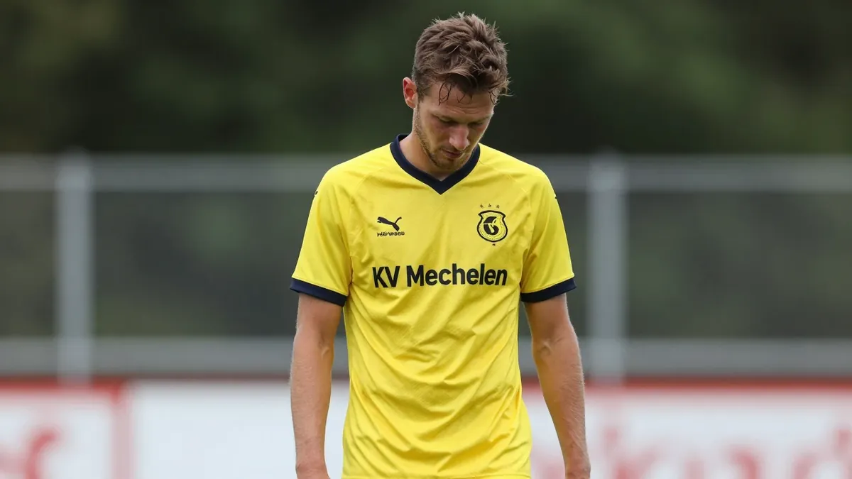 A 30-year-old KV Mechelen player, wearing a yellow jersey, looks dejected after missing a chance, photographed with a...